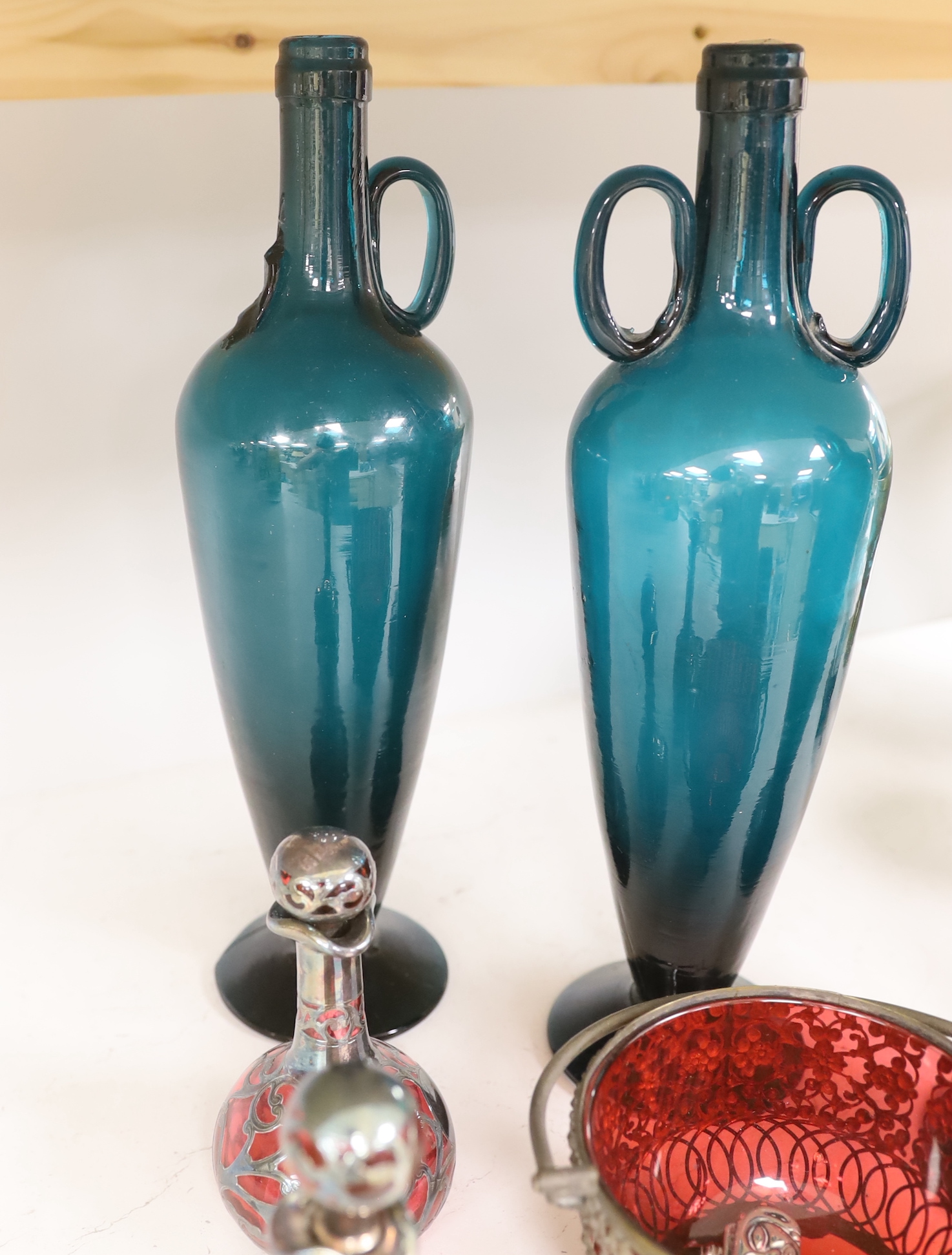 Three green glass flasks, a ruby glass basket and two overlaid ruby glass scent bottles, tallest 33cm (5)